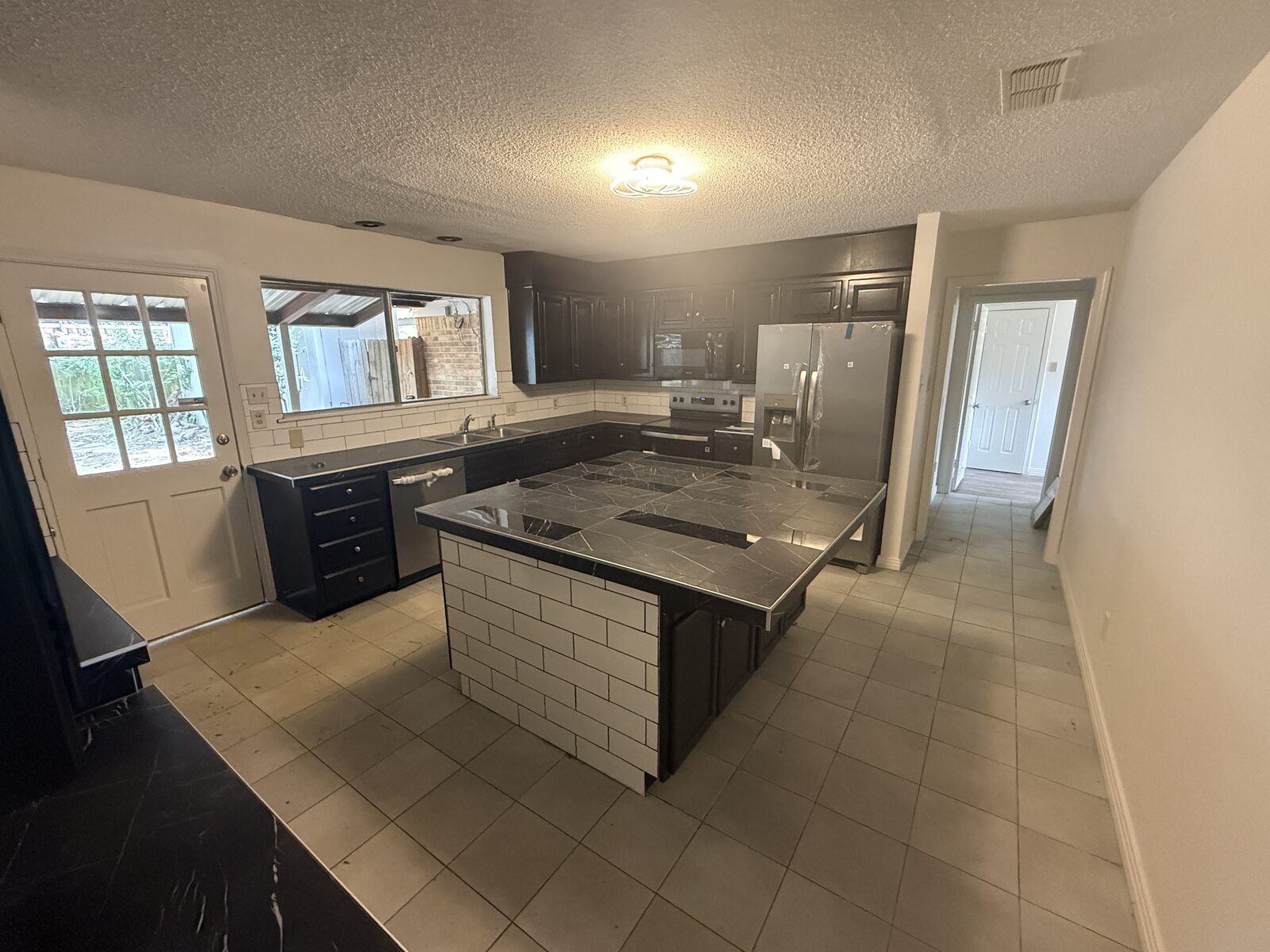 Renovated kitchen with center island and stainless appliances