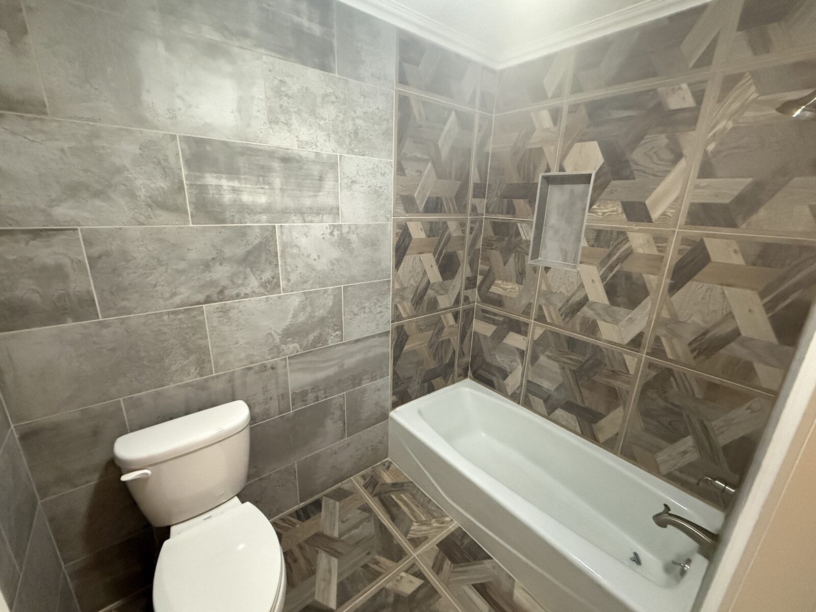 Full bath with patterned tile tub surround