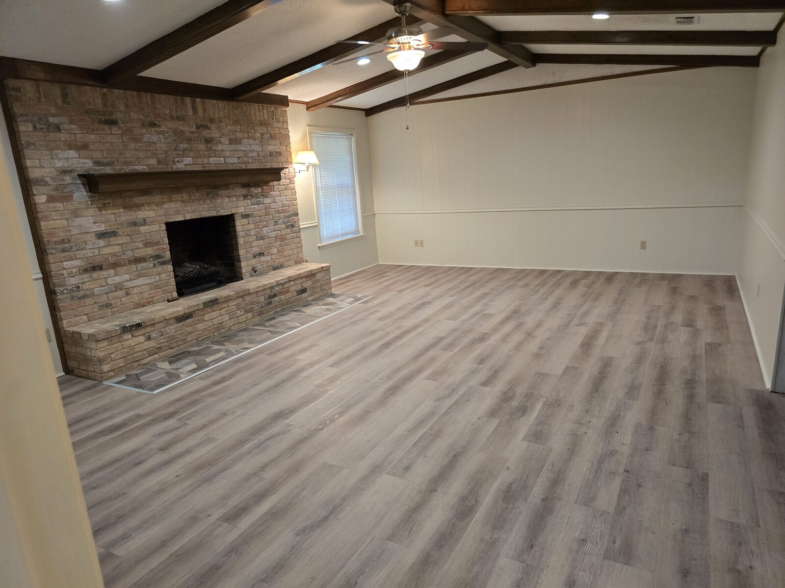 Living room with stone fireplace & beamed ceiling